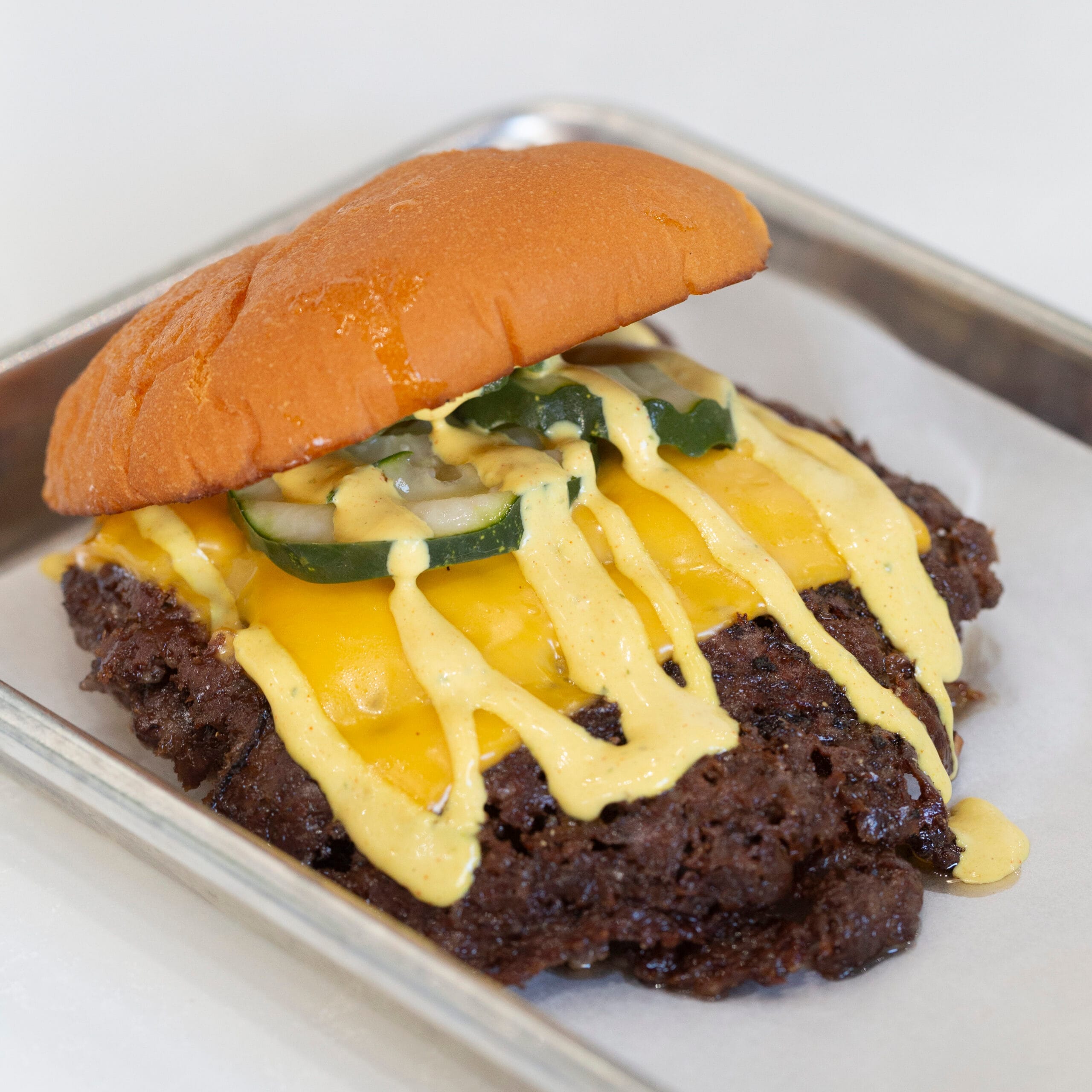 Classic Hammer Burger with crisp smashed beef, melted cheese and pickles